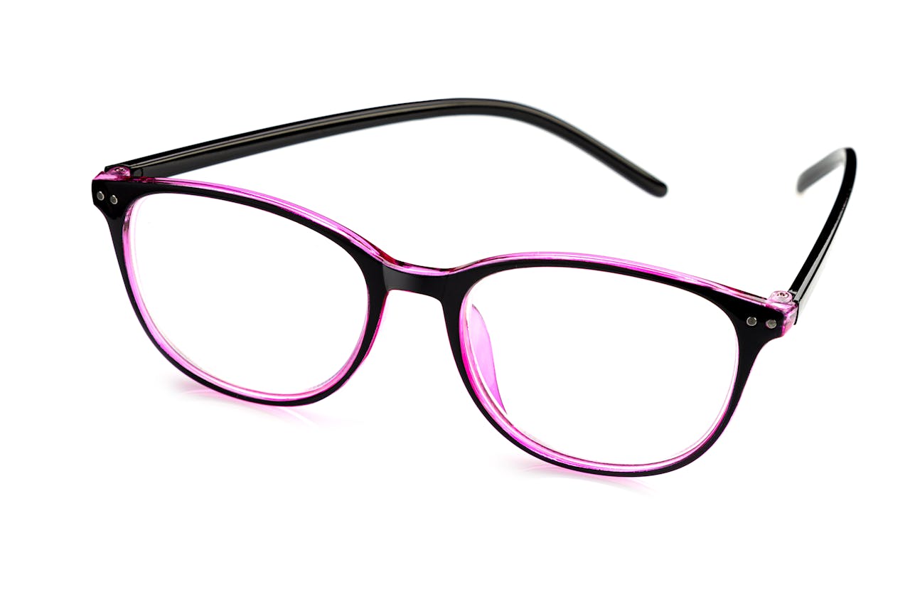 Close-up of fashionable pink and black eyeglasses on a white surface, showcasing modern eyewear design.